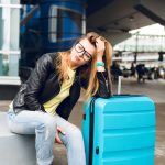 Pasageră cu bagaj în aeroport după anularea unui zbor