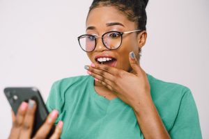 Persoană care citește informații și recenzii pe telefon înainte de cumpărare